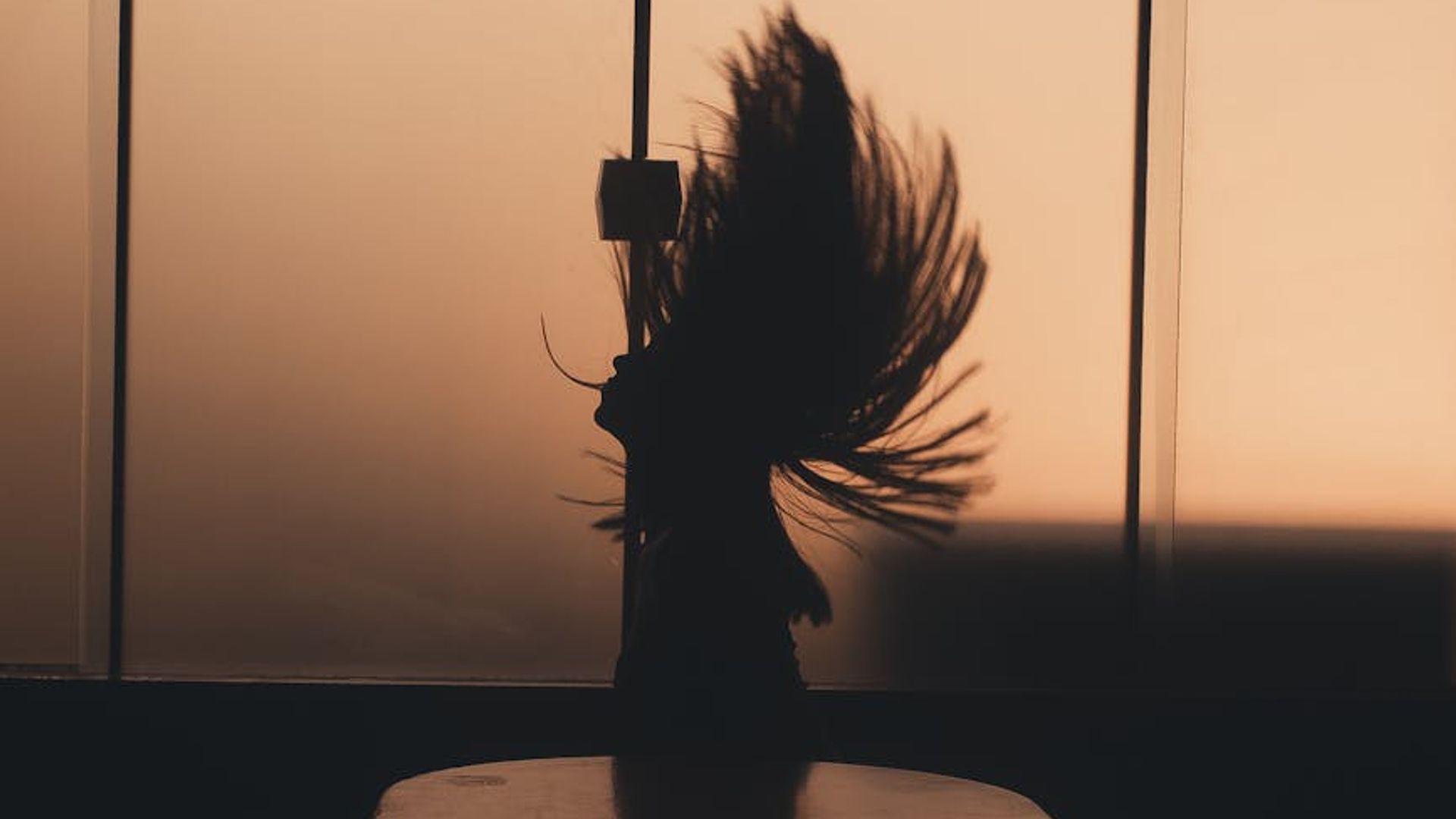 Abstract silhouette of a person in a dynamic movement pose against a dark background.